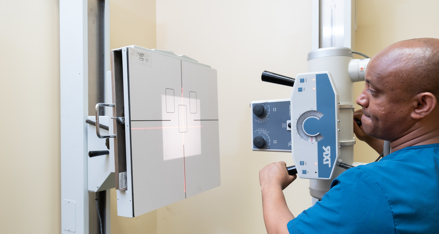 Clinician operating X-ray equipment at St. Gabriel Clinic